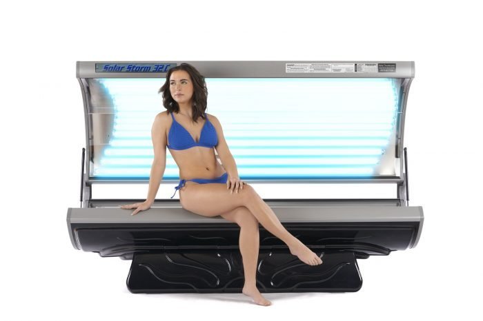 Solar Storm 32C, 32 Lamp Commercial Tanning Bed, open, with model seated